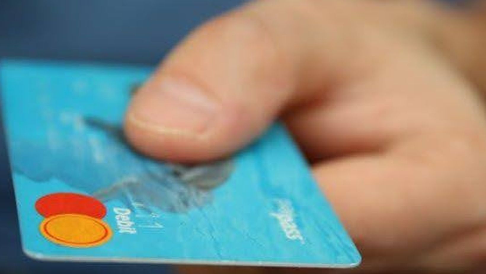a close-up of a hand holding a debit card